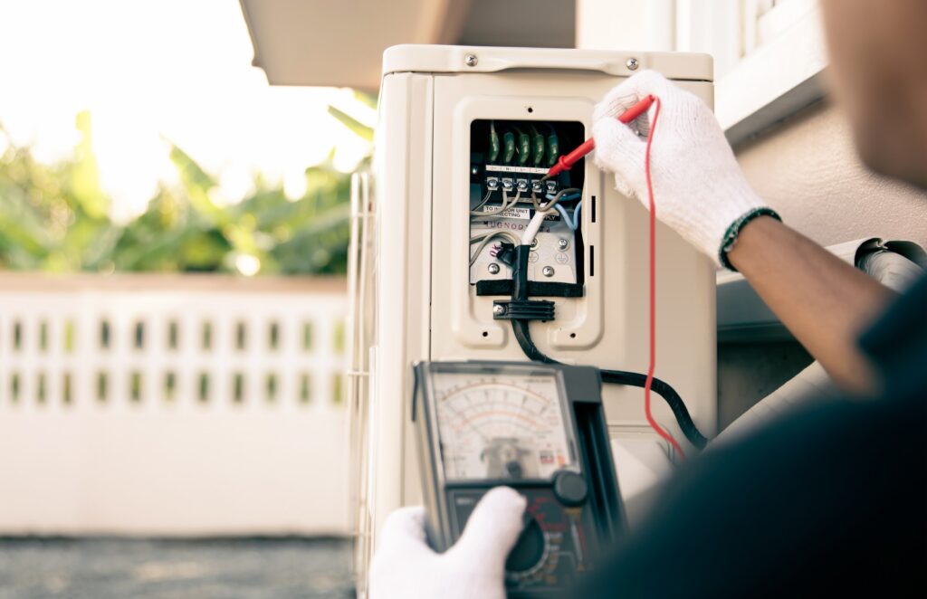 technician using measuring tool checking electric outdoor air compressor